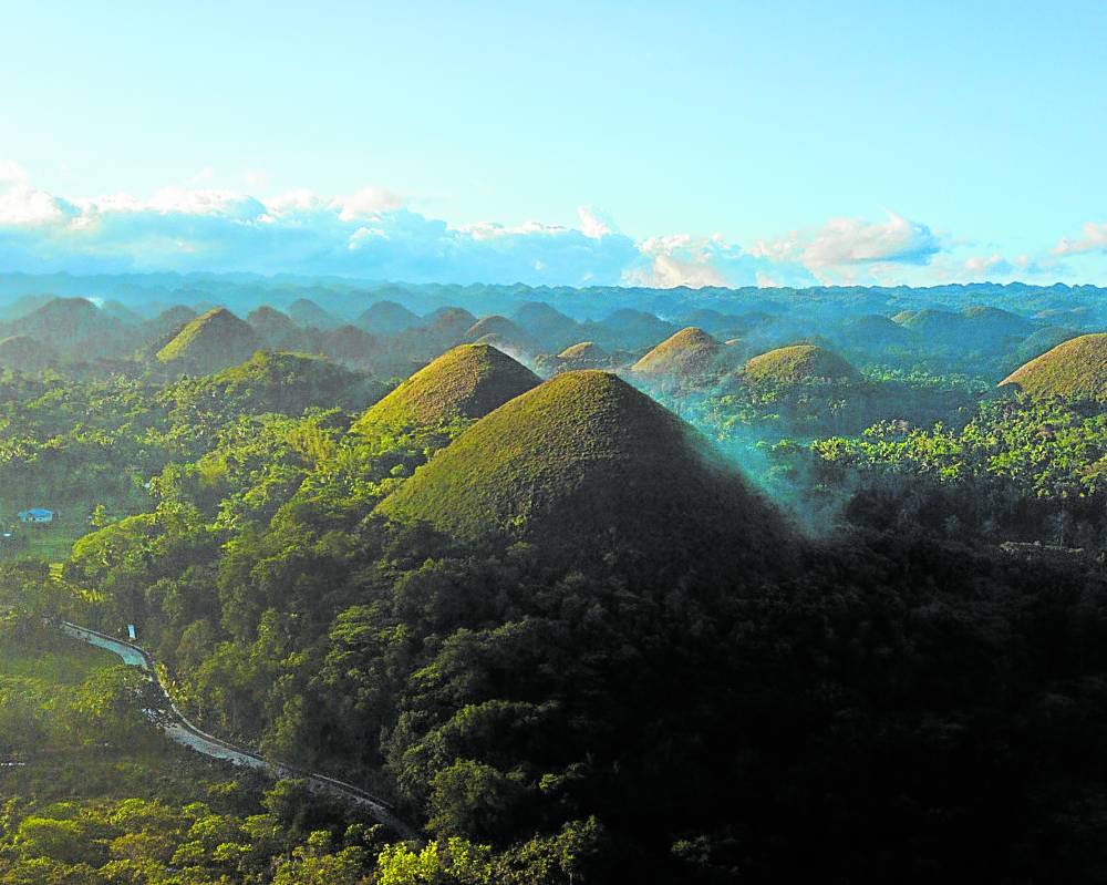 Green rolling hills beneath a clear blue sky